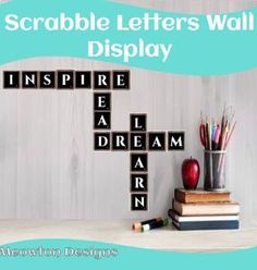 a crossword puzzle with the words scrabble letters wall display next to an apple, books and pencils