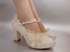 a woman's white high heeled shoes with lace and bows on the heels