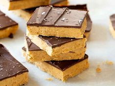 several pieces of peanut butter bars stacked on top of each other with chocolate frosting