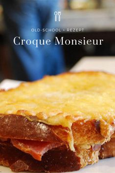 a close up of a piece of food on a plate with the words croque monsieur