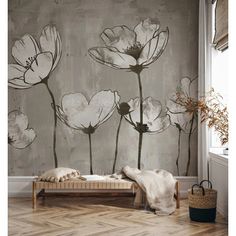 a wall with flowers painted on it and a bed in the foreground, next to a window