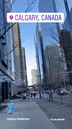 there is a sign that says calgary, canada in front of tall buildings on the street