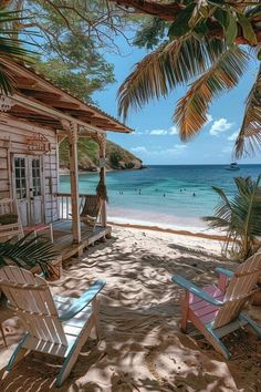 two lawn chairs sitting on top of a sandy beach next to the ocean and palm trees