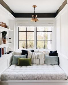 a living room with a couch, window and bookshelf on the wall in front of it