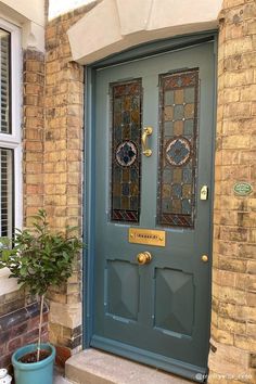 an instagram photo of a blue front door with decorative glass panels on the side