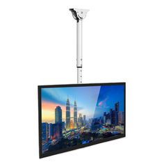 a flat screen tv mounted to the side of a white wall with a cityscape in the background