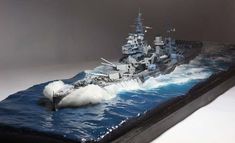 a plastic model of a navy ship in the ocean