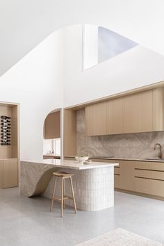 a modern kitchen with an island countertop and stools in the middle of the room