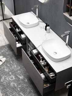 two sinks are shown in the middle of a bathroom with drawers on both sides and an open drawer underneath them