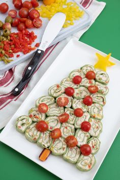 a white plate topped with food next to a cutting board filled with tomatoes and cucumbers