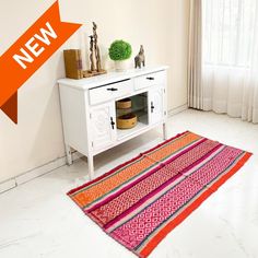 a white table with a red and orange rug next to it