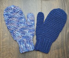 two knit mittens sitting on top of a wooden table