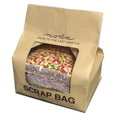 a brown paper bag filled with colorful fabric