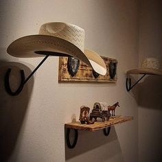 two hats are hanging on the wall next to some shelves with toy horses and cowboy hats