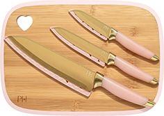 three knives on a cutting board next to a heart