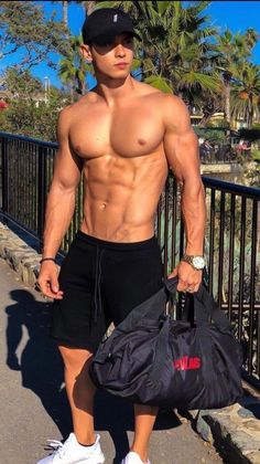 a shirtless man with no shirt holding a duffel bag