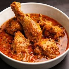 a white bowl filled with chicken wings covered in sauce