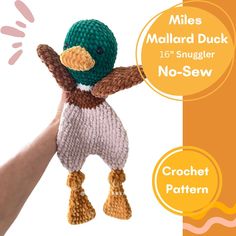 a hand holding a knitted duck with no - sew text below it reads miles mallard duck 10's smugler no - sew