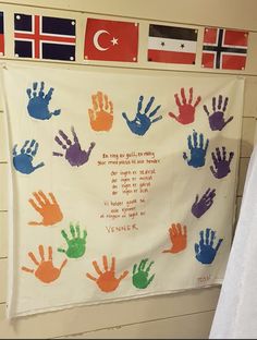 a wall hanging with handprints on it in front of flags and a flag