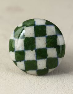 a green and white checkered ball sitting on top of a table