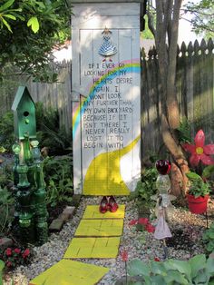 the garden is decorated with flowers, plants and a sign for someone's house