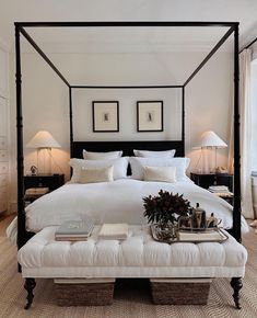 a bed with white sheets and pillows in a bedroom next to two lamps on either side of the bed