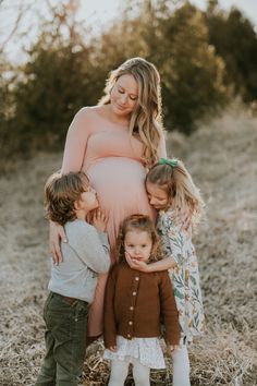 a pregnant woman and her three children in a field