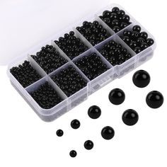 black beads in a plastic container and some are on the table next to each other