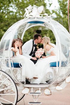 a bride and groom kissing in a horse drawn carriage