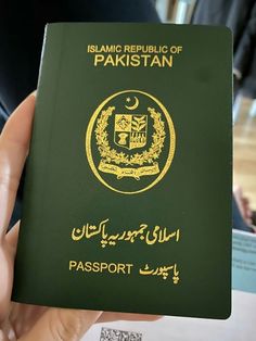 a person holding up a green passport in their hand with the word, islamic republic of pakistan on it