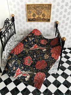 a black and white checkered floor next to a bed with red flowers on it