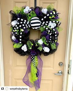 the wreath is decorated with black, white and green decorations on it's front door