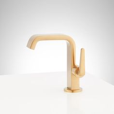 a gold faucet sitting on top of a white counter