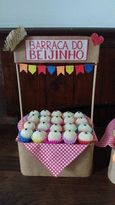 cupcakes are displayed in front of a stand for sale