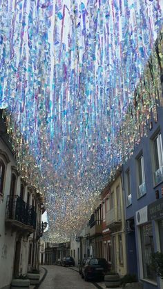 a street filled with lots of colorful glass bottles hanging from the side of it's ceiling