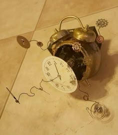 an old clock sitting on the floor with gears attached to it's back end