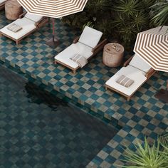 an aerial view of two lounge chairs and umbrellas next to a swimming pool area