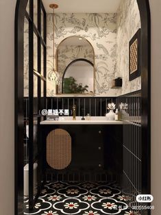 a black and white bathroom with an arched doorway leading to the sink area, mirror, and wallpaper