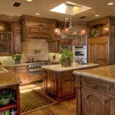 a large kitchen with wooden cabinets and granite counter tops, along with a chandelier hanging from the ceiling