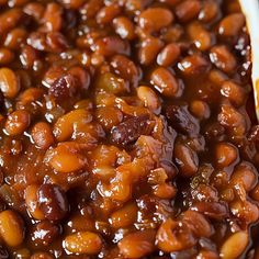 baked beans are in a white dish on a table