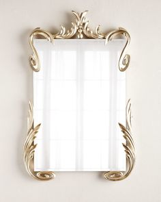 a gold framed mirror hanging on the wall