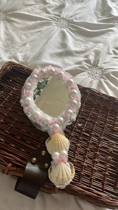 a wicker basket with a mirror and seashells on it