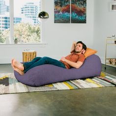 a man laying on a bean bag chair in a living room