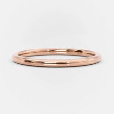 a rose gold wedding band on a white background