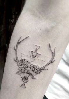 a black and white photo of a deer's antlers with flowers