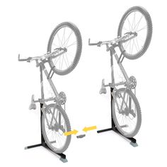 two bicycle racks with wheels on each side and yellow arrows pointing to the opposite direction