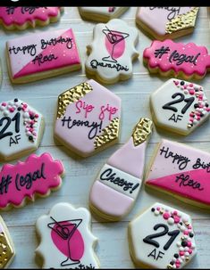 decorated cookies with pink and white frosting are arranged on a wooden table, one is for 21st birthday