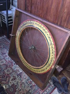 an old bicycle wheel is on display in a wooden box with writing all over it