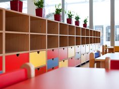 the shelves are filled with colorful drawers and planters on top of each shelf in this classroom