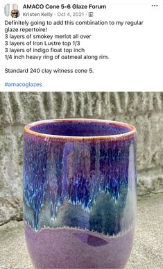 a purple cup sitting on top of a table next to a stone wall with text above it